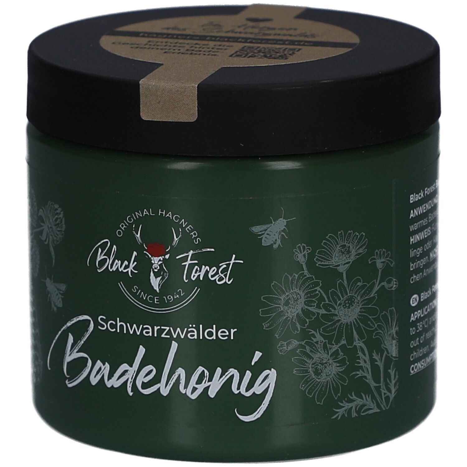 Grünes Glas mit schwarzem Deckel. Aufschrift: Black Forest, Badehonig. Illustrationen von Blumen und Bienen.