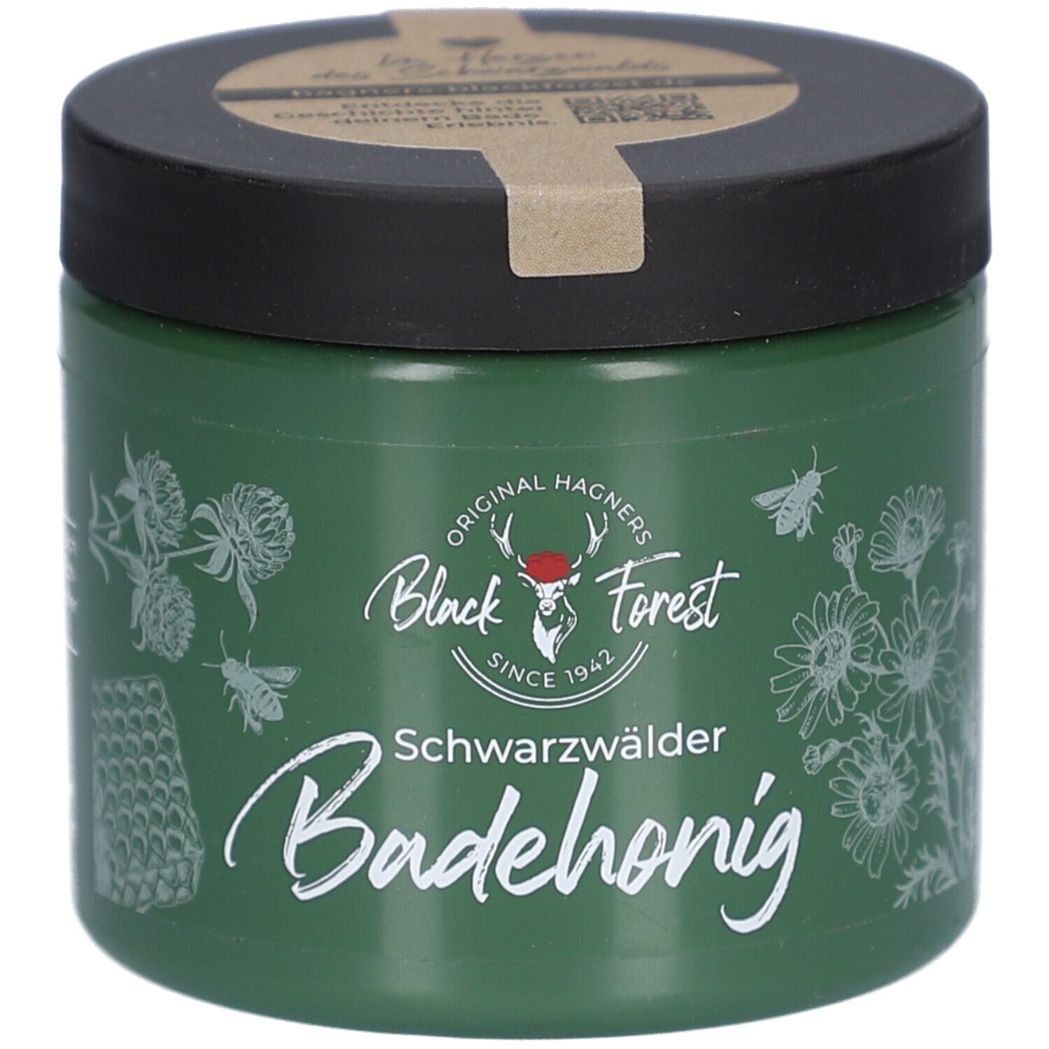 Grünes Glas mit schwarzem Deckel. Aufschrift: Black Forest, Badehonig. Illustrationen von Blumen und Bienen.