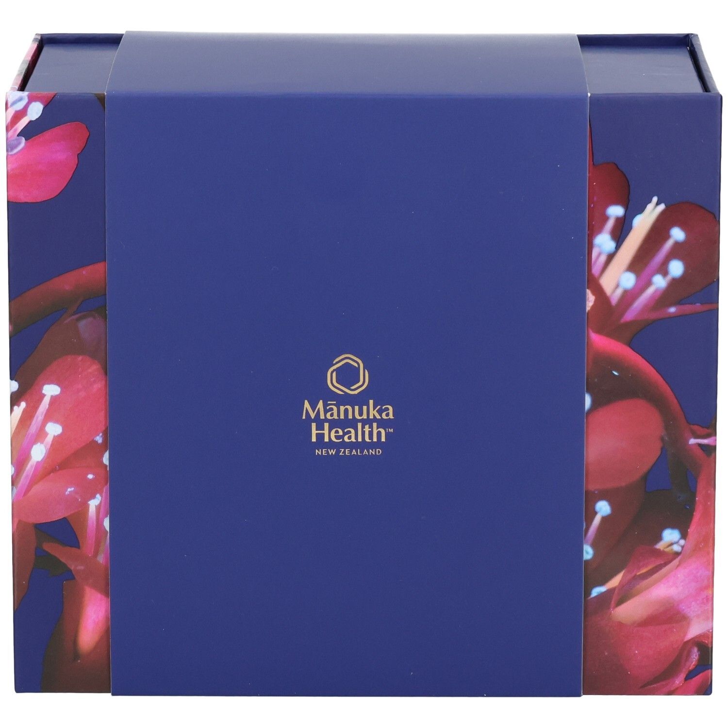 Geschenkbox mit floralem Muster und Logo von Manuka Health New Zealand. Blau-violette Farbe.