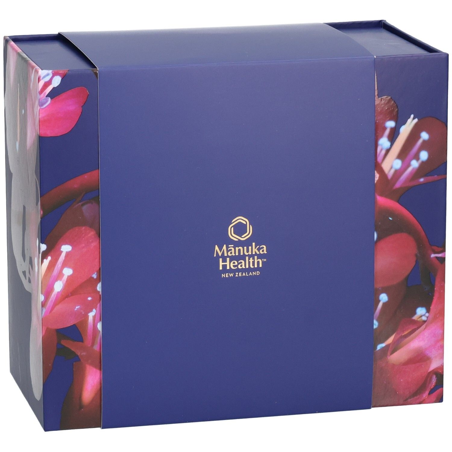 Geschenkbox mit floralem Muster und Logo von Manuka Health New Zealand. Blau-violette Farbe.