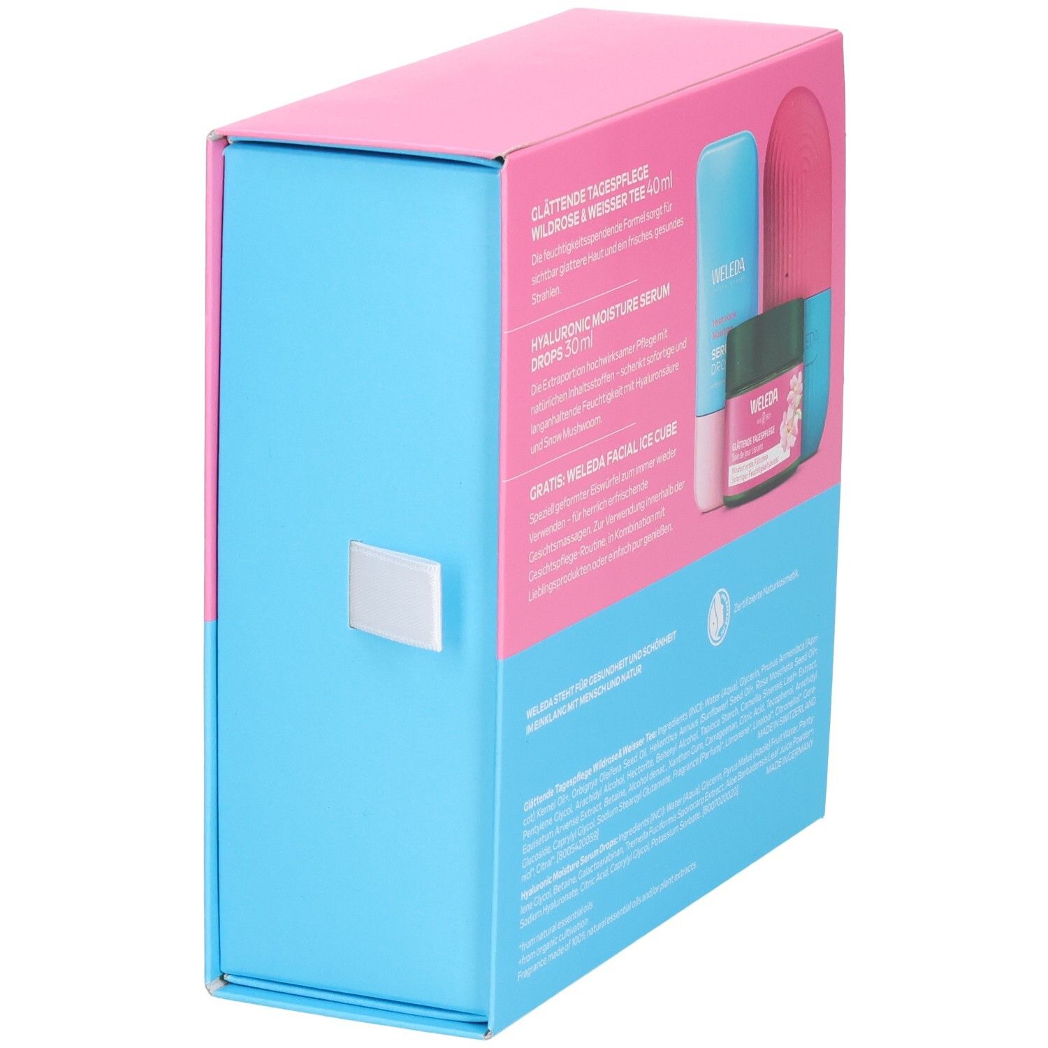 Geschenkset-Box, zweifarbig: Pink und Blau. Produkte teilweise sichtbar. Aufschrift: WELEDA. Seitenansicht.