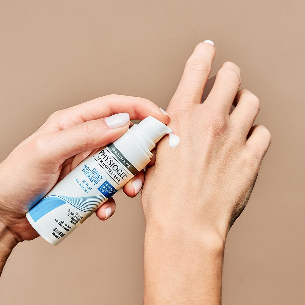 Hände mit Serum. Text: PHYSIOGEL, Daily Moisture Therapy, Serum. Für normale bis trockene Haut.