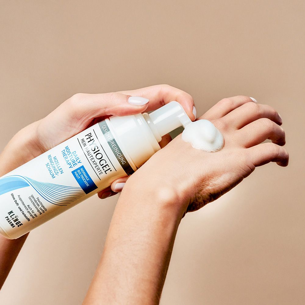 Hand drückt PHYSIOGEL® Reinigungs-Schaum aus der Flasche.