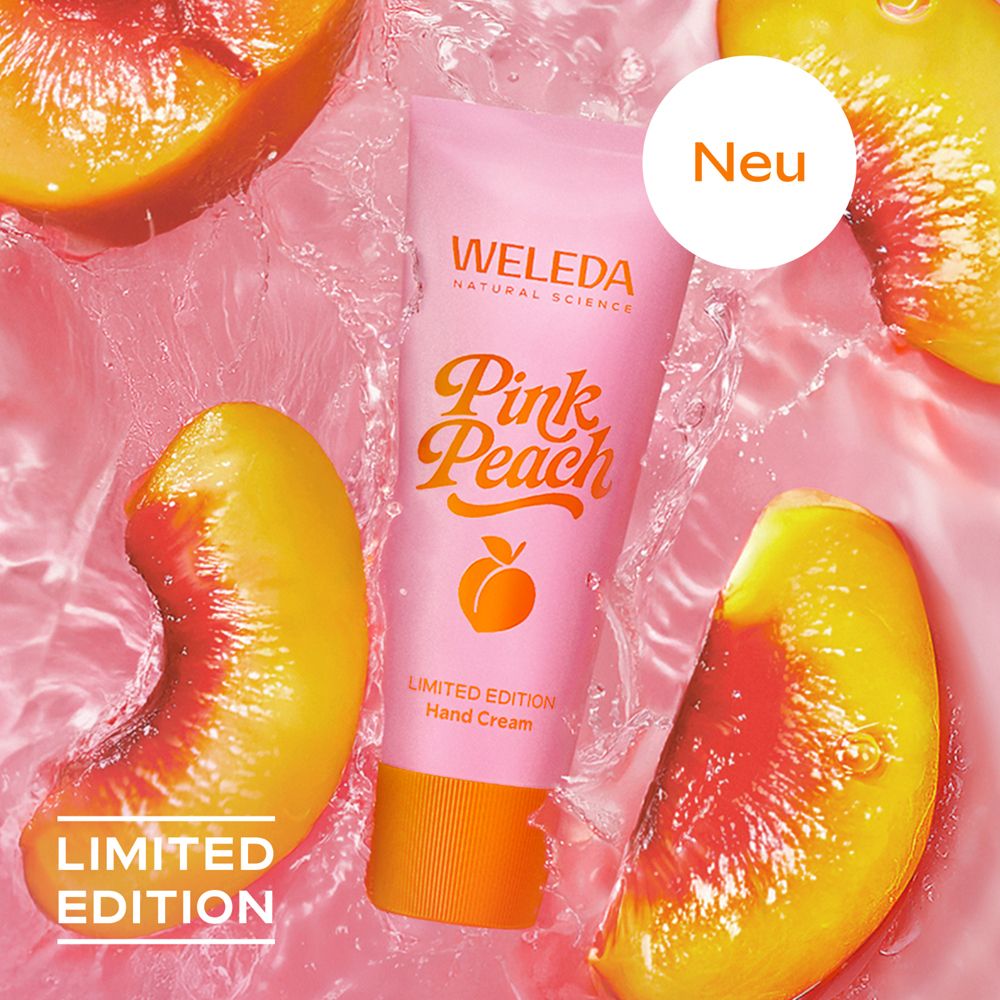 Handcreme-Tube im Wasser mit Pfirsichstücken. Aufschrift: Pink Peach, Limited Edition, Weleda. Neu-Label.