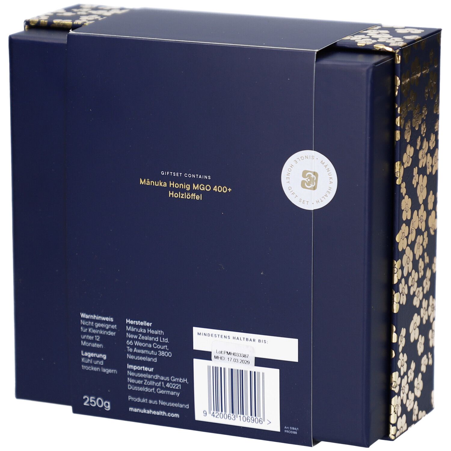 Rückseite der Geschenkbox. Text: Mānuka Honig MGO 400+, Holz-Löffel. Hersteller- und Mindesthaltbarkeitsdatum.