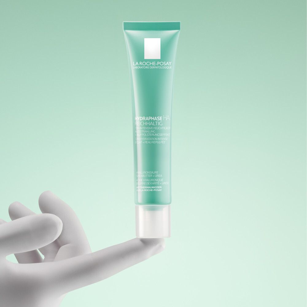 Grüne Tube in weißer Hand. Aufschrift: La Roche-Posay, Hydraphase HA Reichhaltig.