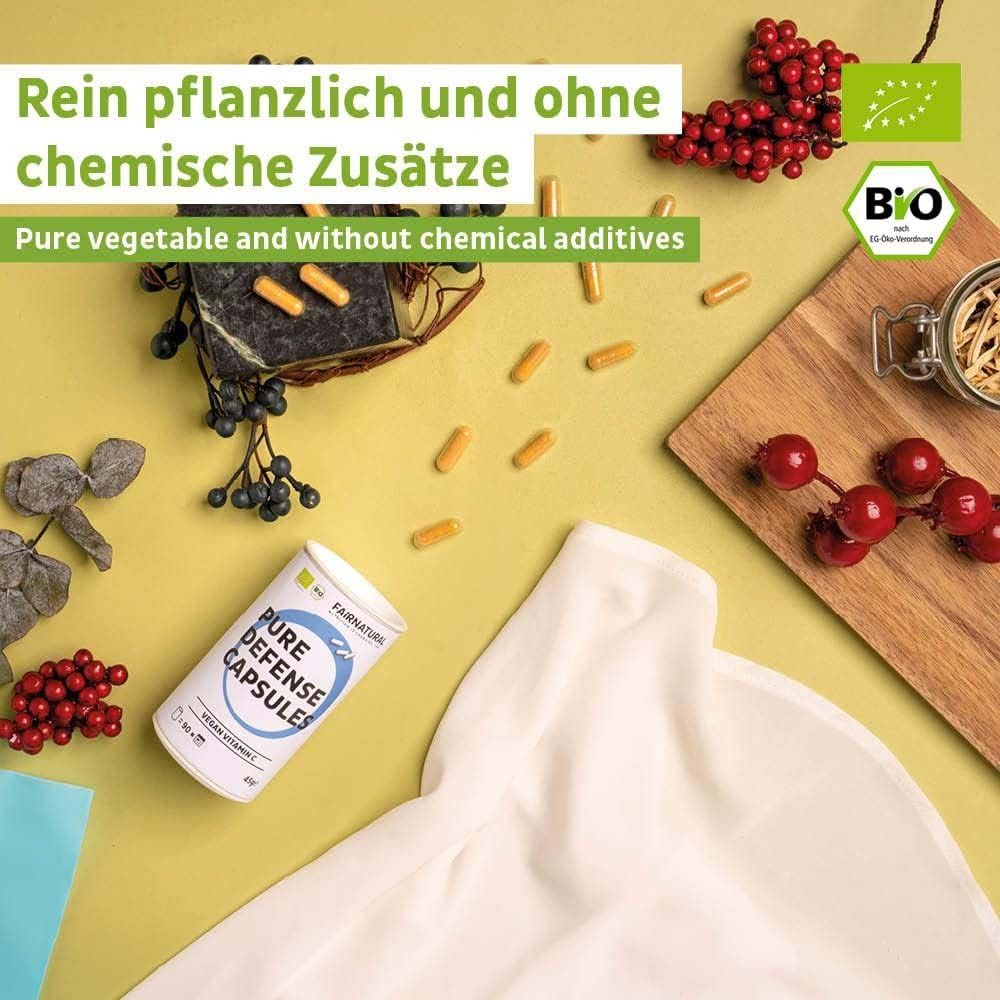 Produktverpackung mit Kapseln und Früchten. Dose mit Aufschrift: Pure Defense Capsules, Vegan Vitamin C. Bio-Siegel. Gelber Hintergrund.