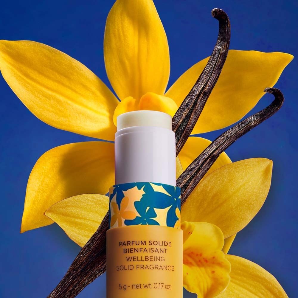 Produkt mit gelben Blüten und Vanilleschoten. Zylindrischer Behälter. Text: Parfum Solide Bienfaisant, 5g.