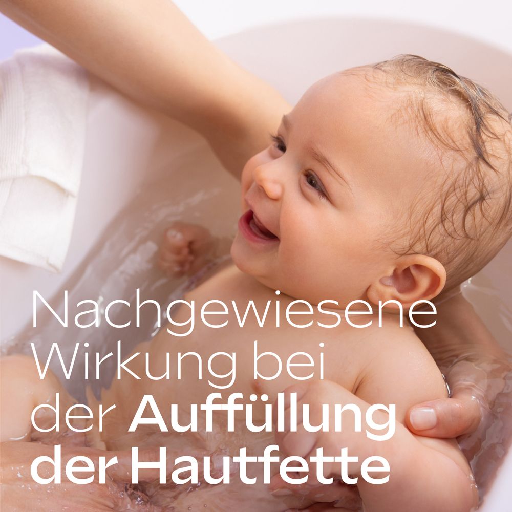 Lächelndes Baby in der Badewanne, Hände halten es. Text: Nachgewiesene Wirkung bei der Auffüllung der Hautfette.