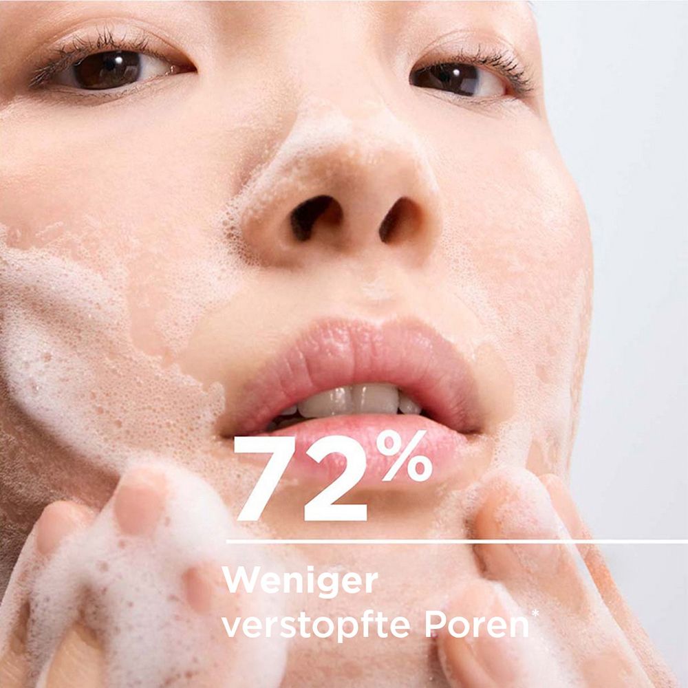 Nahaufnahme eines Gesichts, das mit schäumendem Reinigungsprodukt gewaschen wird. 72% weniger verstopfte Poren.