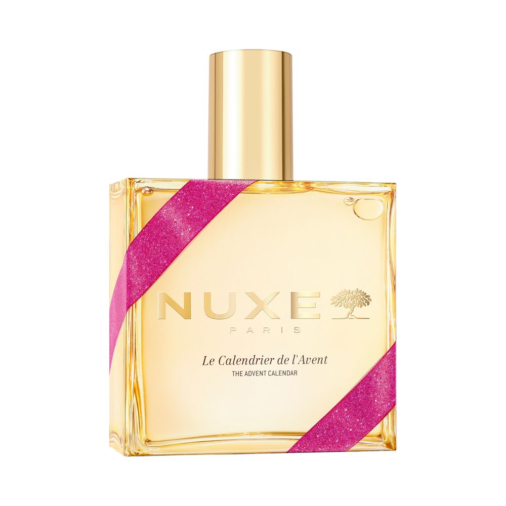 Eine goldene Flasche mit Nuxe Logo und pinkem Band, beschriftet 'Le Calendrier de l'Avent'.