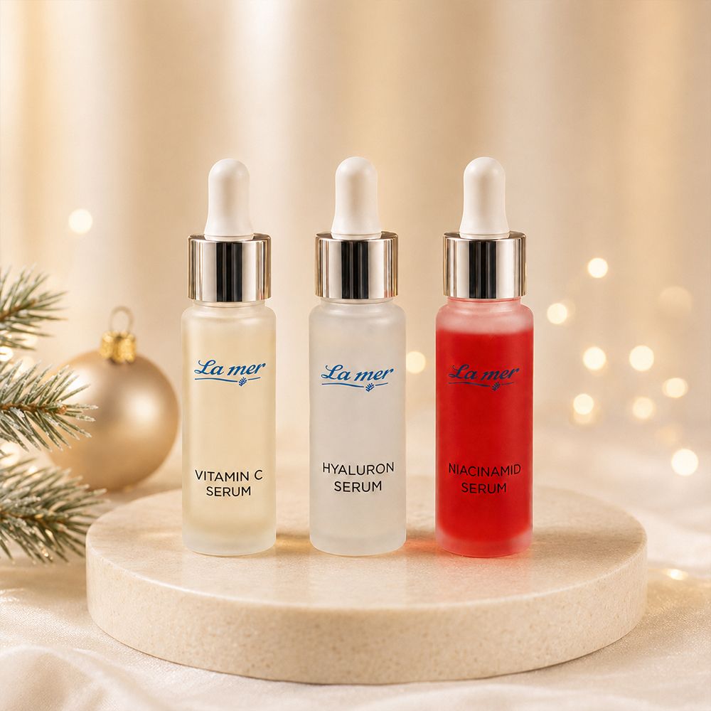 Drei La Mer Ampullen: Vitamin C Serum, Hyaluron Serum, Niacinamid Serum auf einem Steinpodest.