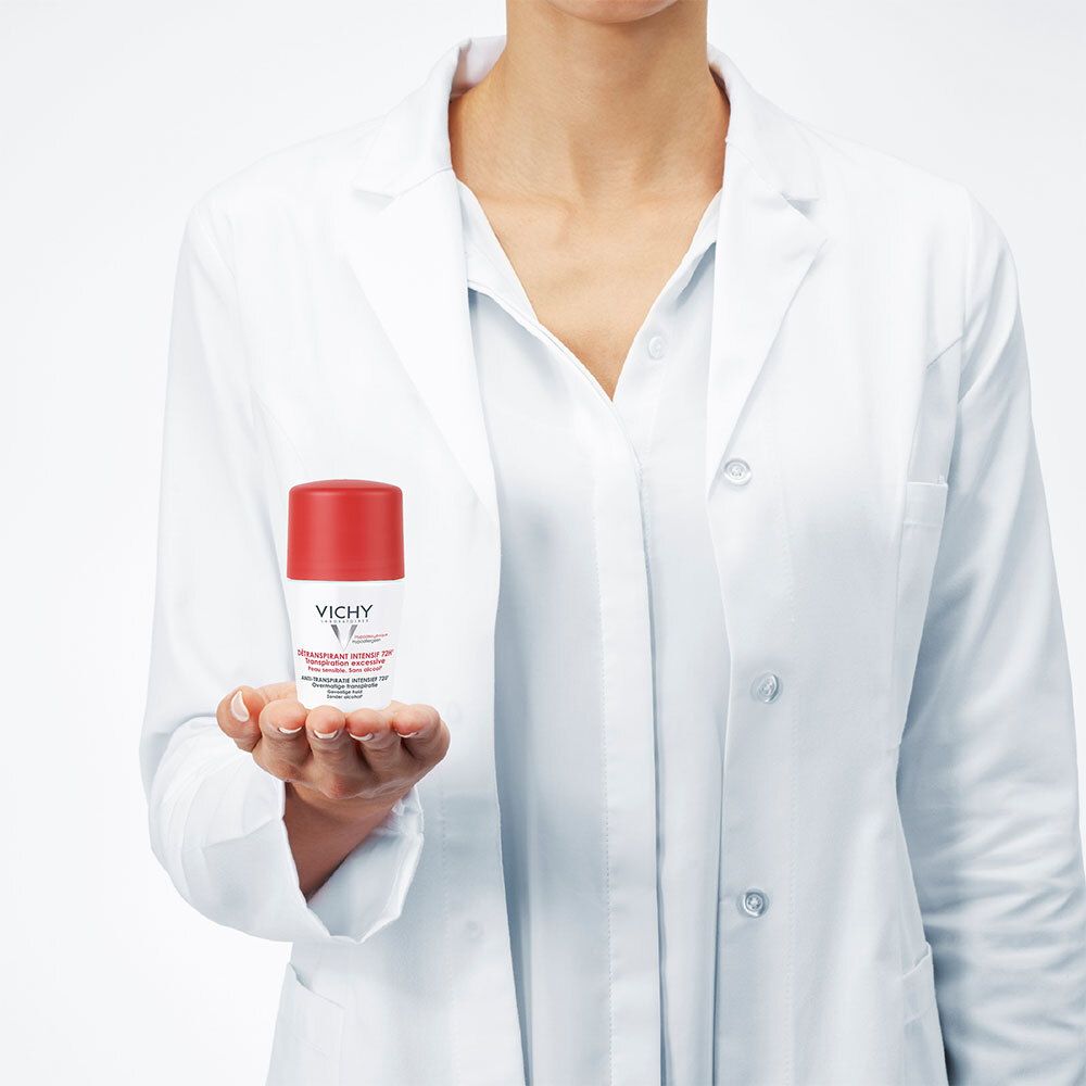 Personne en blouse blanche tenant un roll-on Vichy Détranspirant Intensif 72h dans sa main.