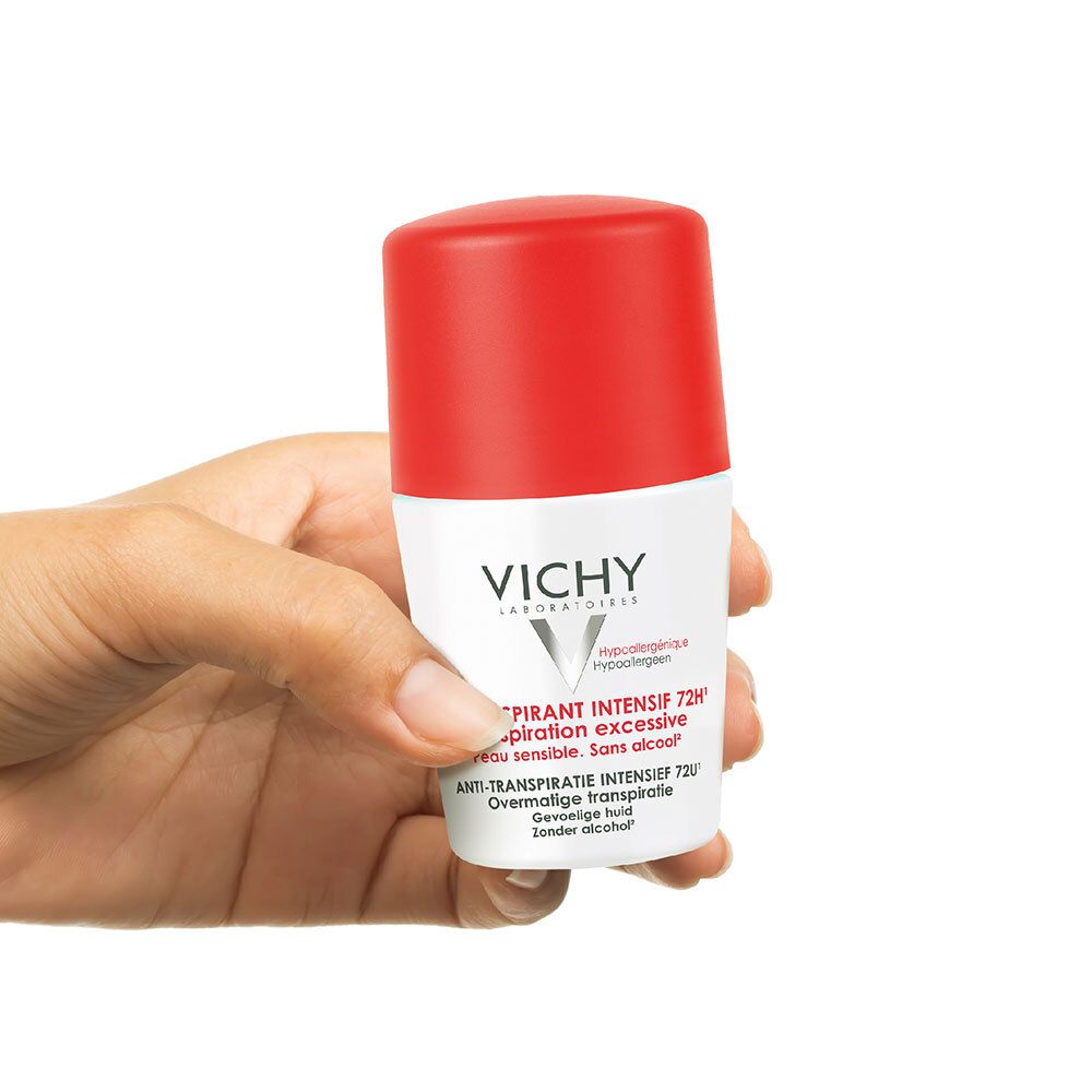 Main tenant un roll-on Vichy Détranspirant Intensif 72h. Couvercle rouge, flacon blanc. Marque Vichy.