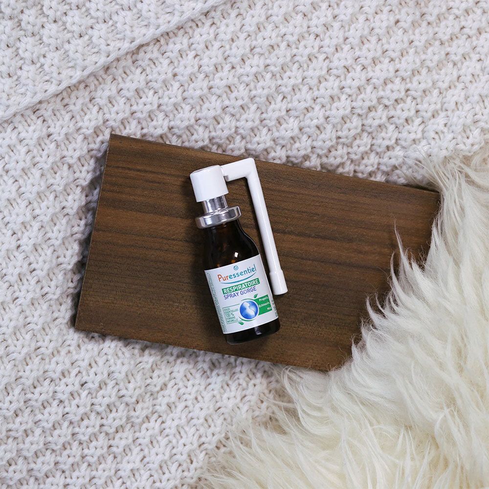 Flacon marron avec vaporisateur blanc. PURESSENTIEL RESPIRATOIRE SPRAY GORGE. Sur une planche de bois et fond doux.