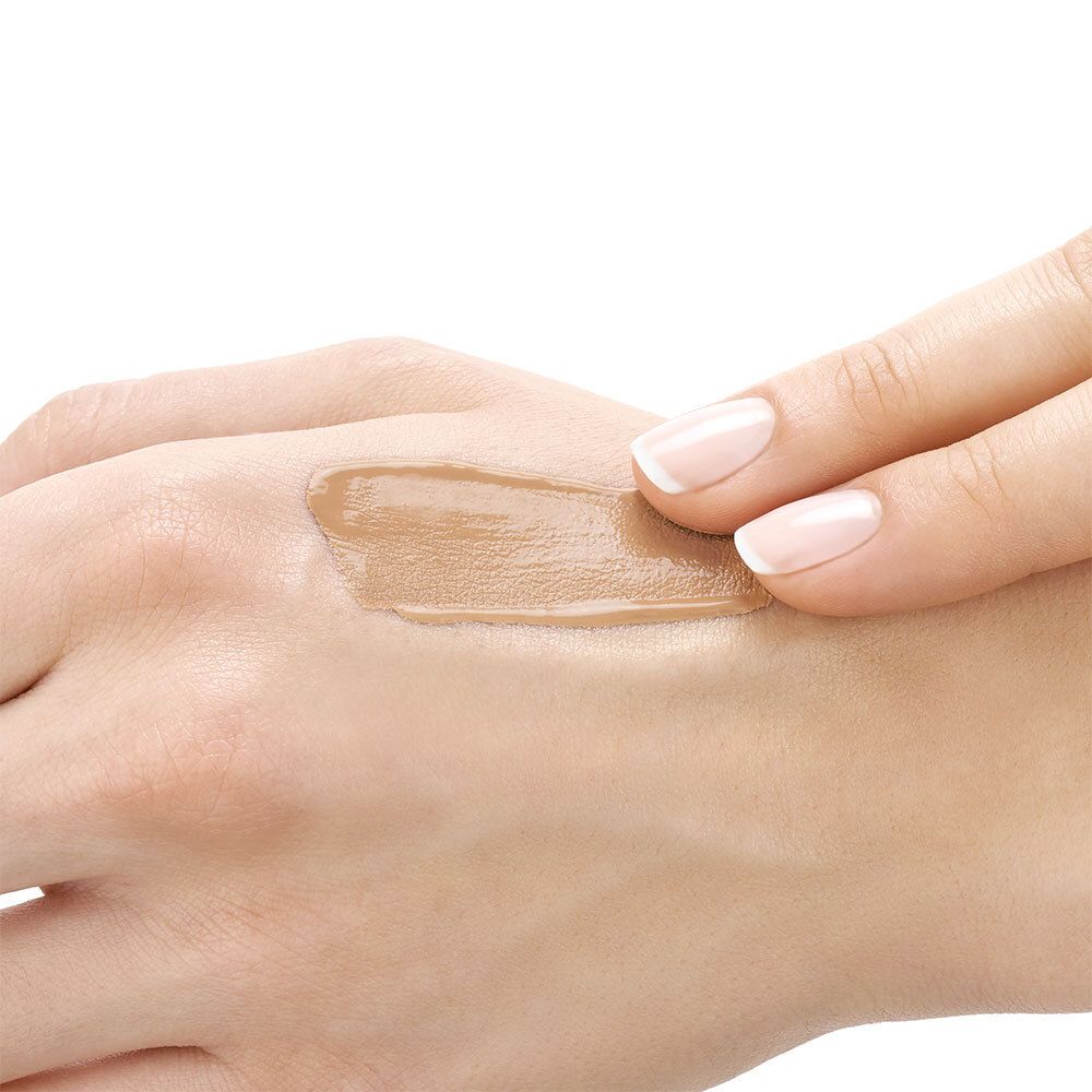 Main avec fond de teint VICHY Dermablend appliqué. Teinte Gold. Peau bronzée. Ongles soignés.