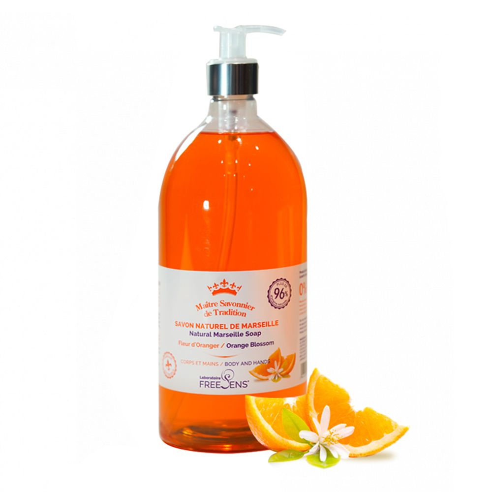 Fles vloeibare zeep. Oranje vloeistof, wit etiket met tekst. Oranjebloesemdecoratie. Pomp.