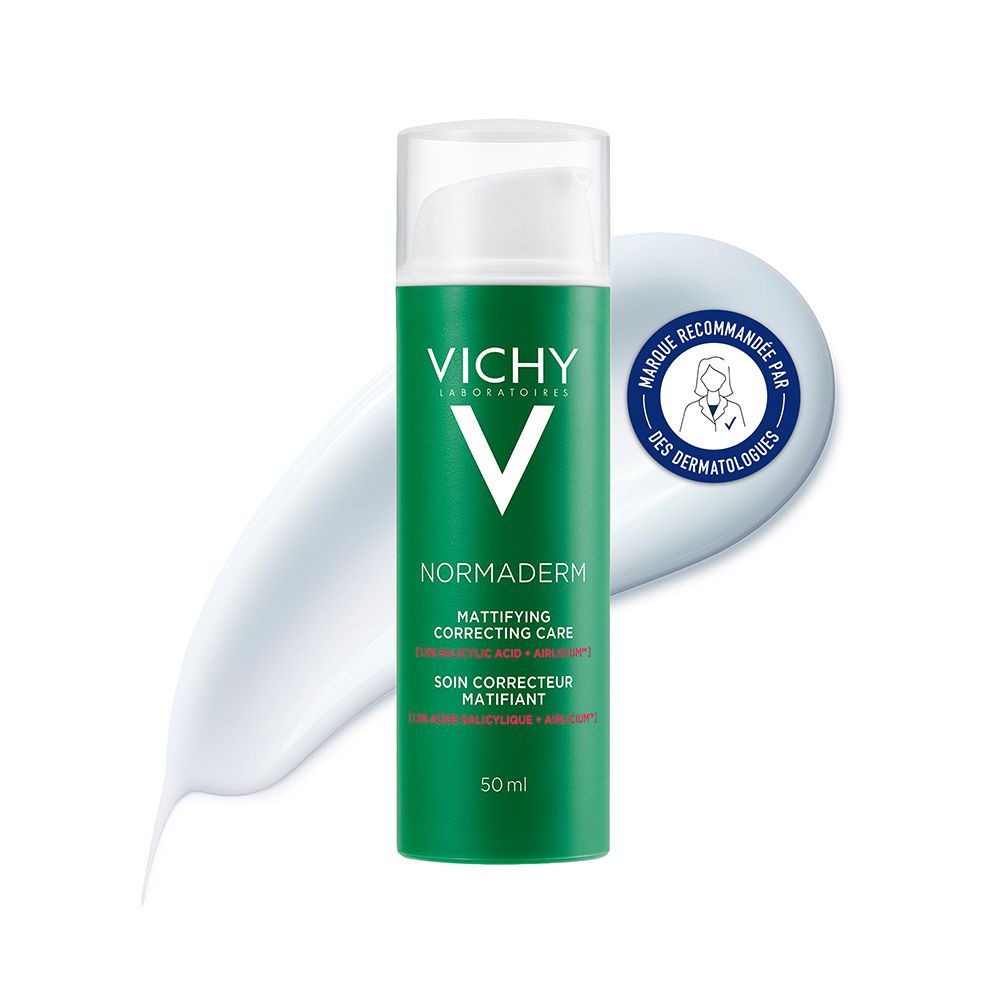 Flacon vert avec bouchon blanc. Logo Vichy et nom du produit. Trace de crème à côté.