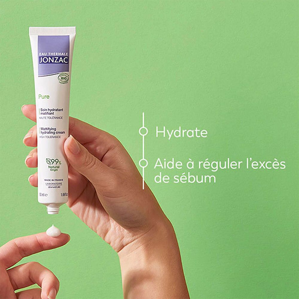 Hand hält Tube. Creme wird aus Tube gedrückt. Auf grünem Hintergrund. Text: Hydratisieren, hilft Talg zu regulieren.