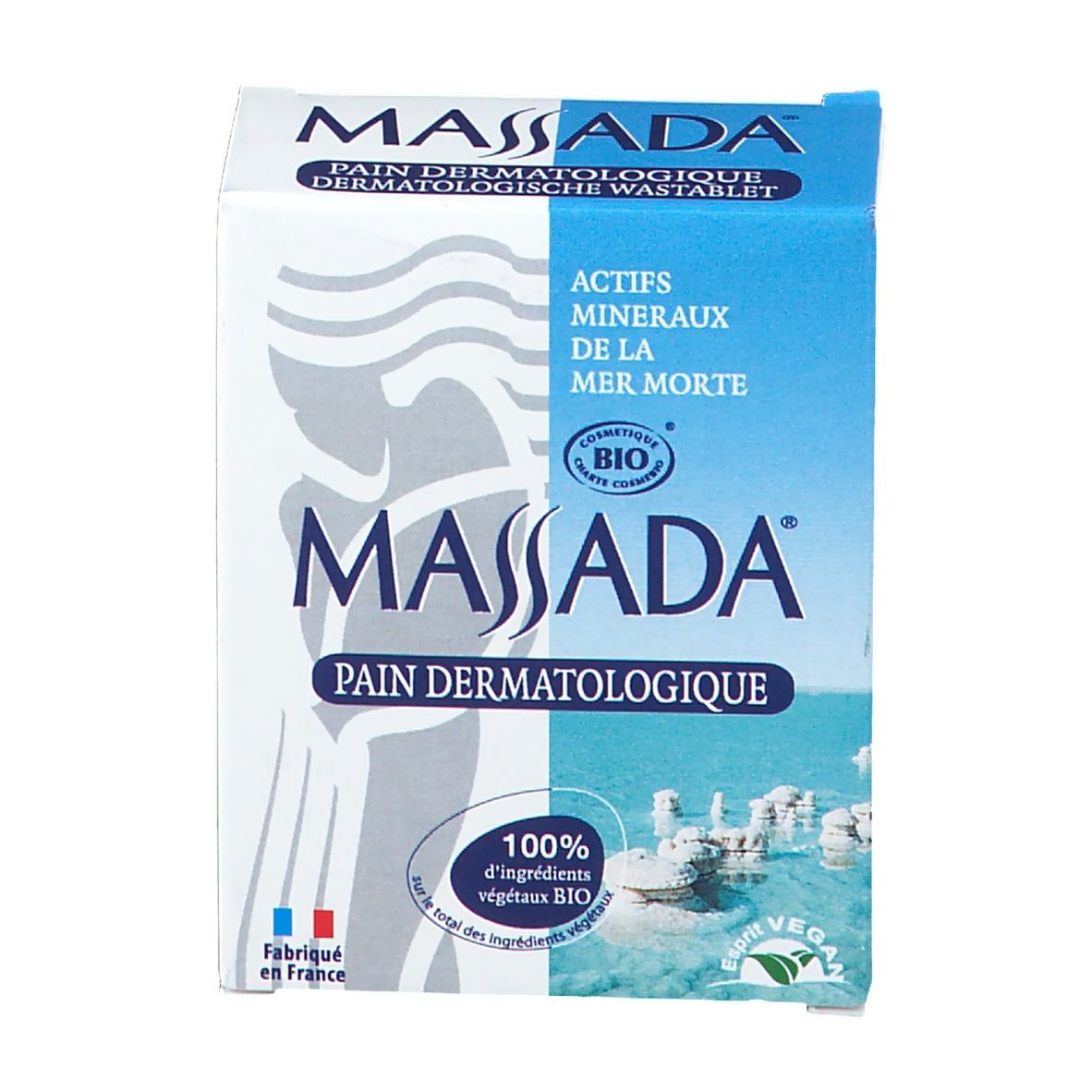 Emballage de savon dermatologique Massada. Boîte blanche et bleue avec nom et logo du produit. Contient certification bio et label vegan.