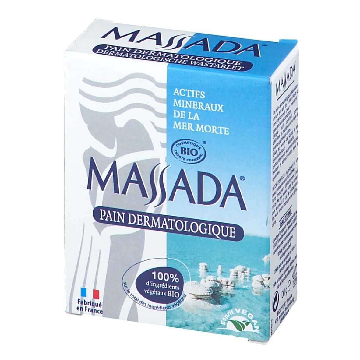 Boîte de savon dermatologique Massada, en biais. Texte sur le côté : ingrédients, mode d'emploi, certification bio, label vegan, origine France.