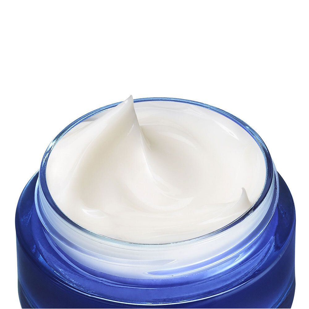 Nahaufnahme der Creme in einem blauen Glas. Weiße Creme mit gewellter Oberfläche.