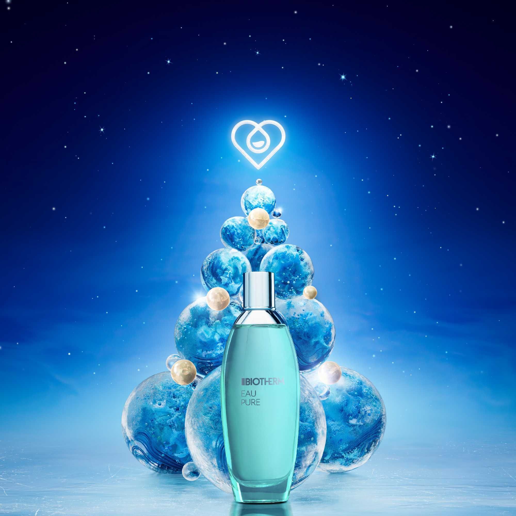 BIOTHERM EAU PURE Körperspray vor blauem Hintergrund. Dekoration in Form eines Weihnachtsbaums aus Kugeln.