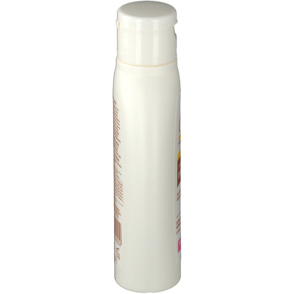 Seitenansicht der weißen Flasche mit Klappverschluss. Text in Französisch und Englisch.