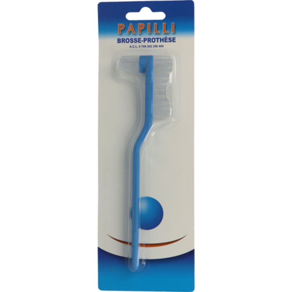 Brosse pour prothèse bleue, emballée. Manche courbé. Inscription "Papilli Brosse-Prothèse" sur l'emballage.