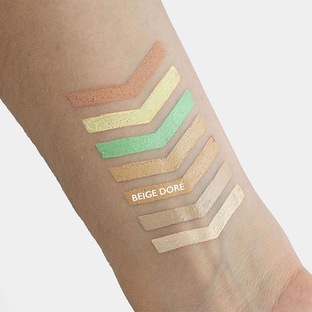 Arm mit Farbmustern von Concealern. Pfeilförmige Farbfelder in verschiedenen Farbtönen. Text: BEIGE DORÉ.
