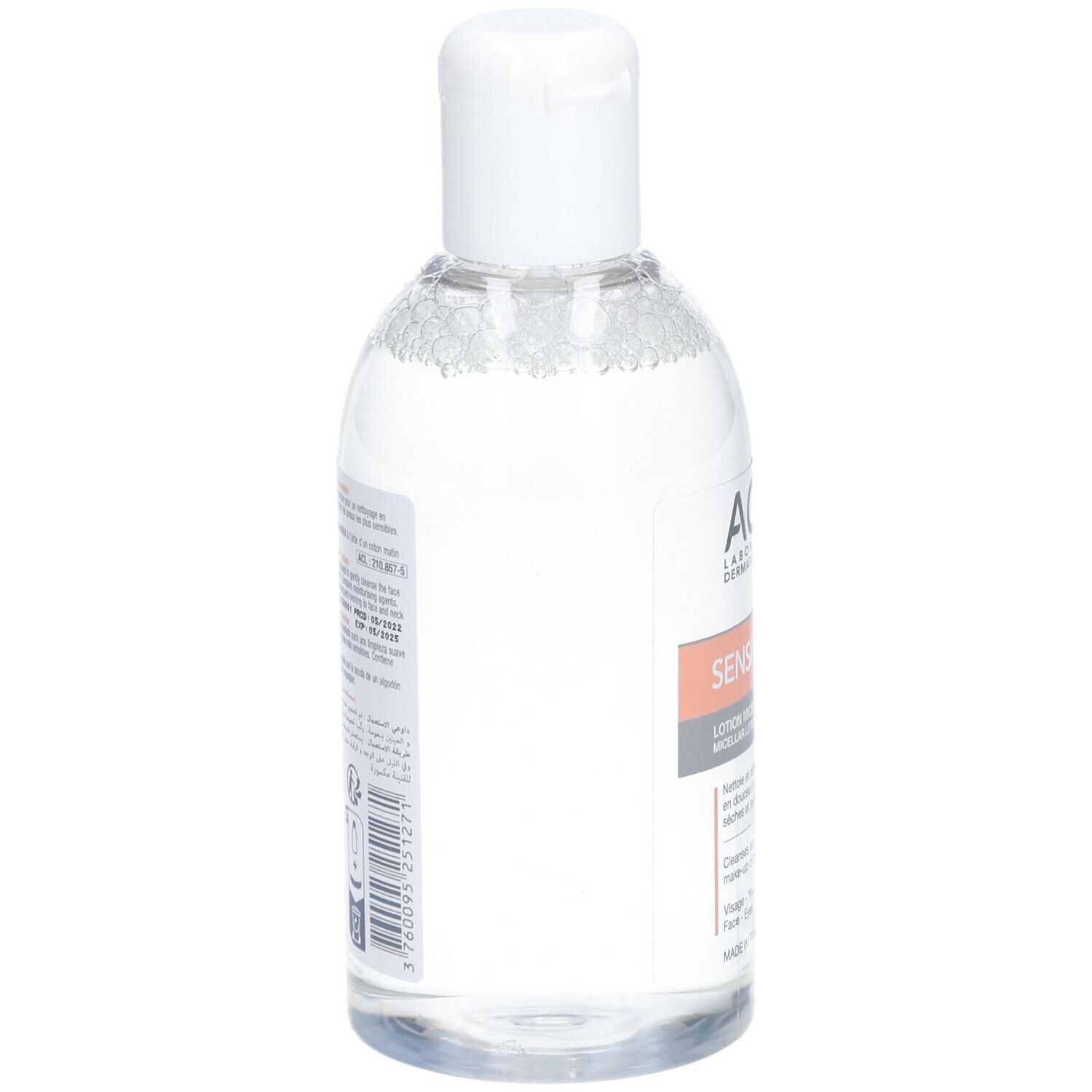 Flacon transparent avec bouchon blanc. Étiquette latérale avec texte et code-barres. Nom du produit illisible.