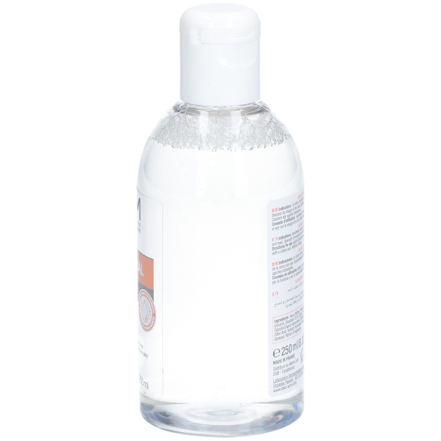 Flacon transparent avec bouchon blanc. Étiquette latérale avec texte. Nom du produit illisible.