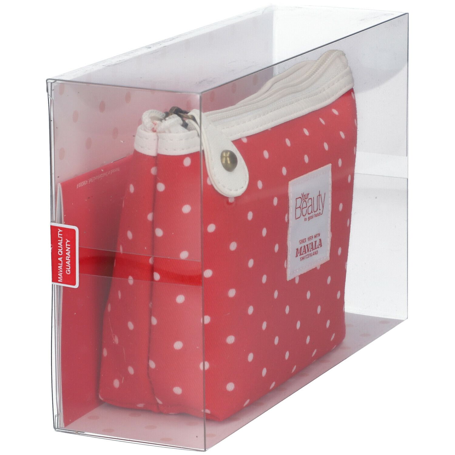 Trousse de toilette rouge à pois blancs, dans emballage transparent. Marque : MAVALA. Fermée par ruban rouge.