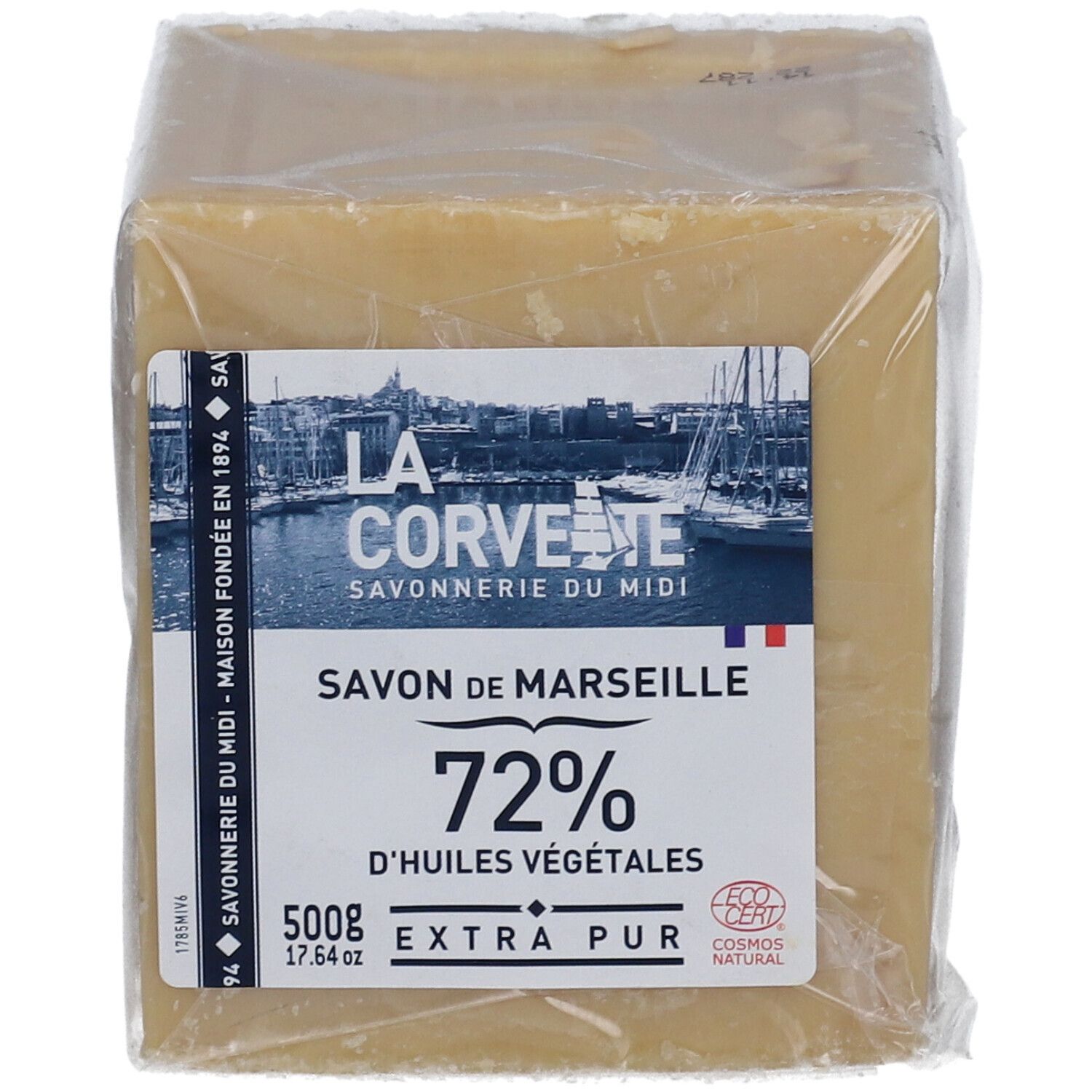 Quadratischer Seifenblock in Folie verpackt. Aufkleber mit Logo, Text: Savon de Marseille, 72% d'huiles végétales, 500g, Extra Pur. Cosmos Natural.