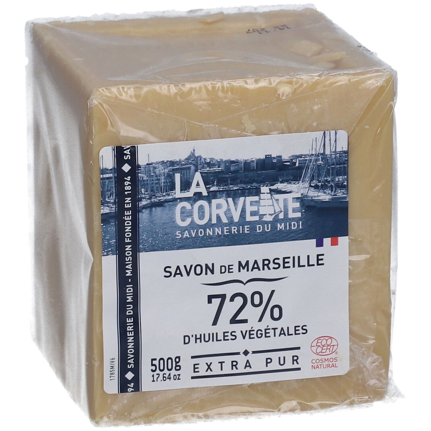 Quadratischer Seifenblock in Folie verpackt. Aufkleber mit Logo, Text: Savon de Marseille, 72% d'huiles végétales, 500g, Extra Pur. Cosmos Natural.