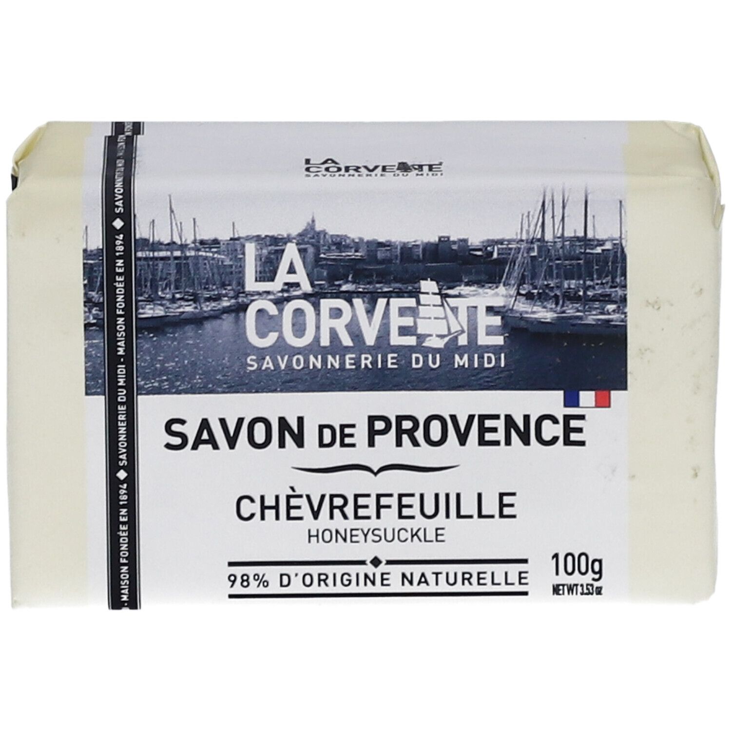 Verpacktes Seifenstück. Aufschrift: Savon de Provence Chèvrefeuille, 98% d'origine naturelle. Logo und Markenname.