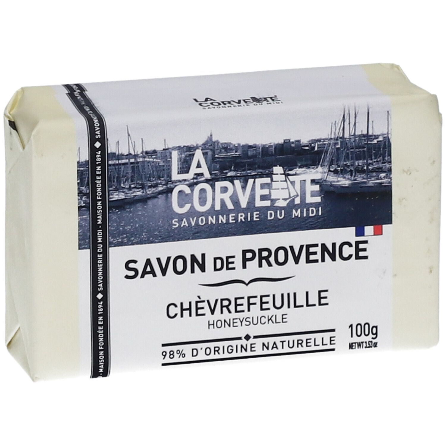 Verpacktes Seifenstück. Aufschrift: Savon de Provence Chèvrefeuille, 98% d'origine naturelle. Logo und Markenname.