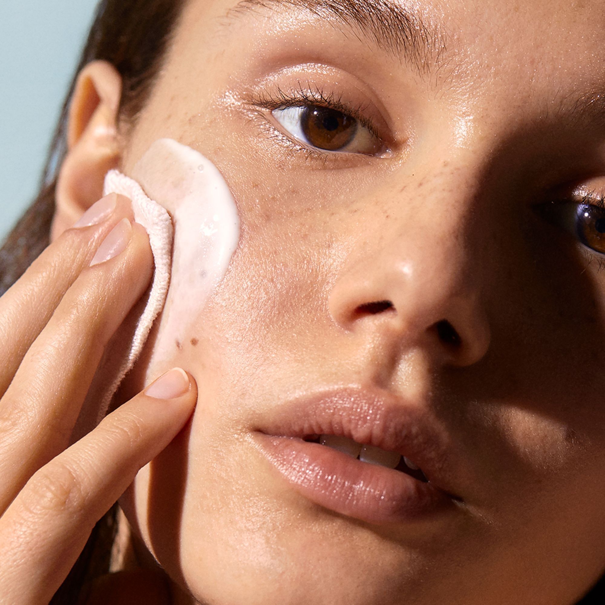 Gros plan d'une femme nettoyant son visage avec un coton. Soin de la peau.