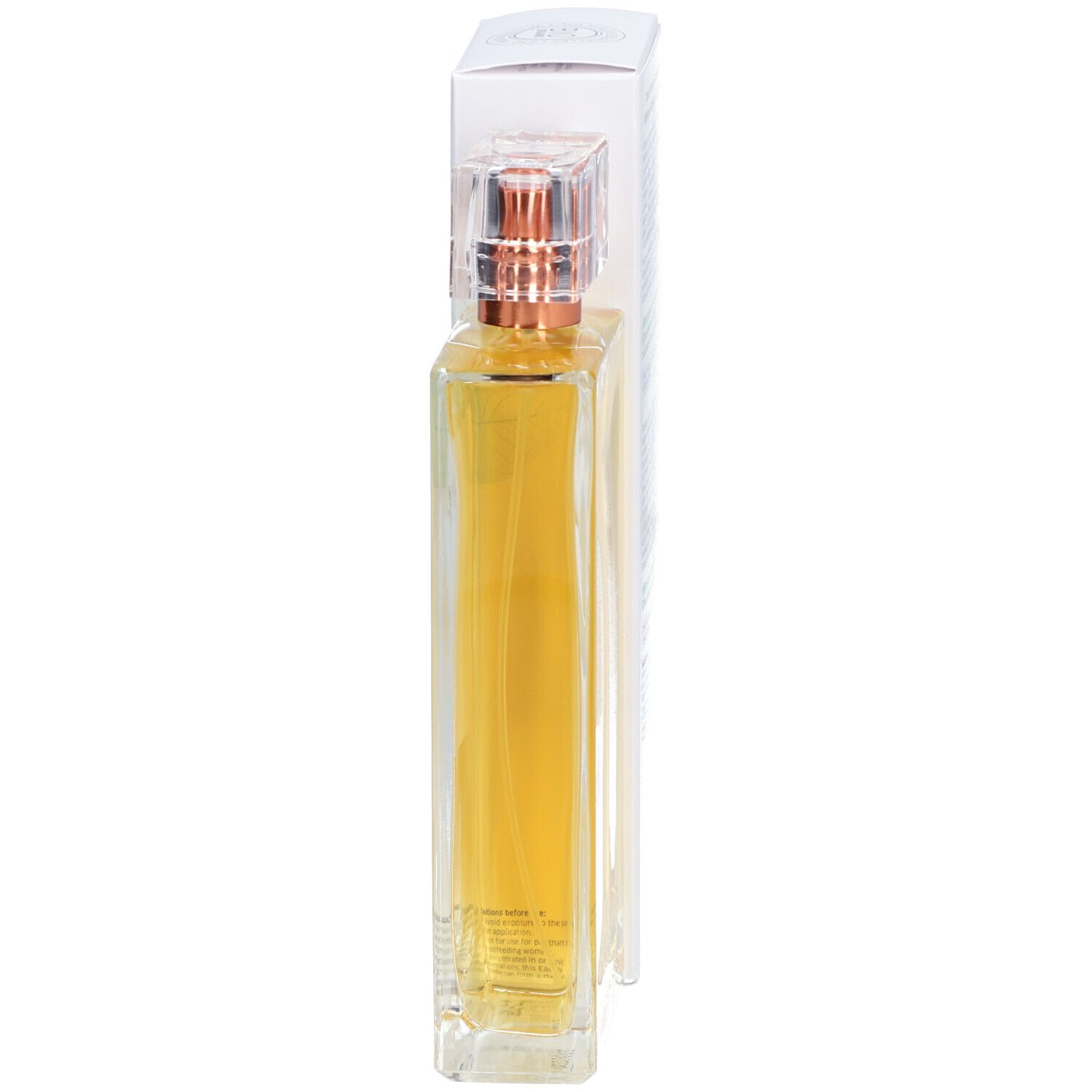 Flacon en verre avec liquide doré et vaporisateur. Emballage blanc en arrière-plan.