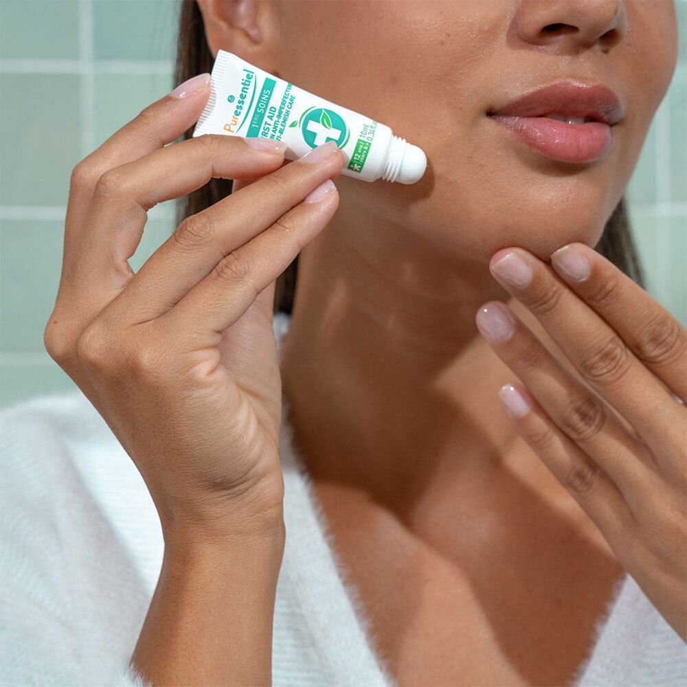 Femme tenant un tube. Inscription : Puressentiel 1. SOINS Anti-imperfections. 10 ml.