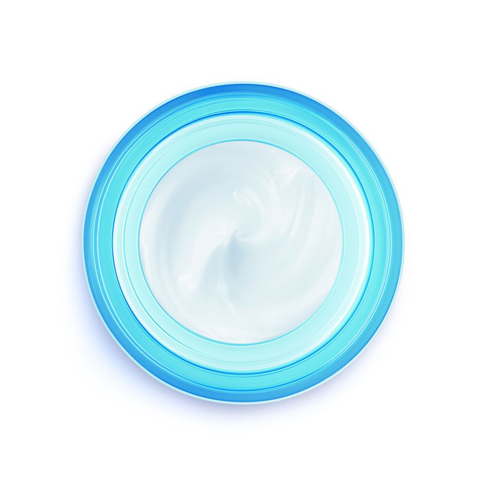 Draufsicht auf blaues Cremeglas mit weißem Deckel. Cremefarbe im Inneren.