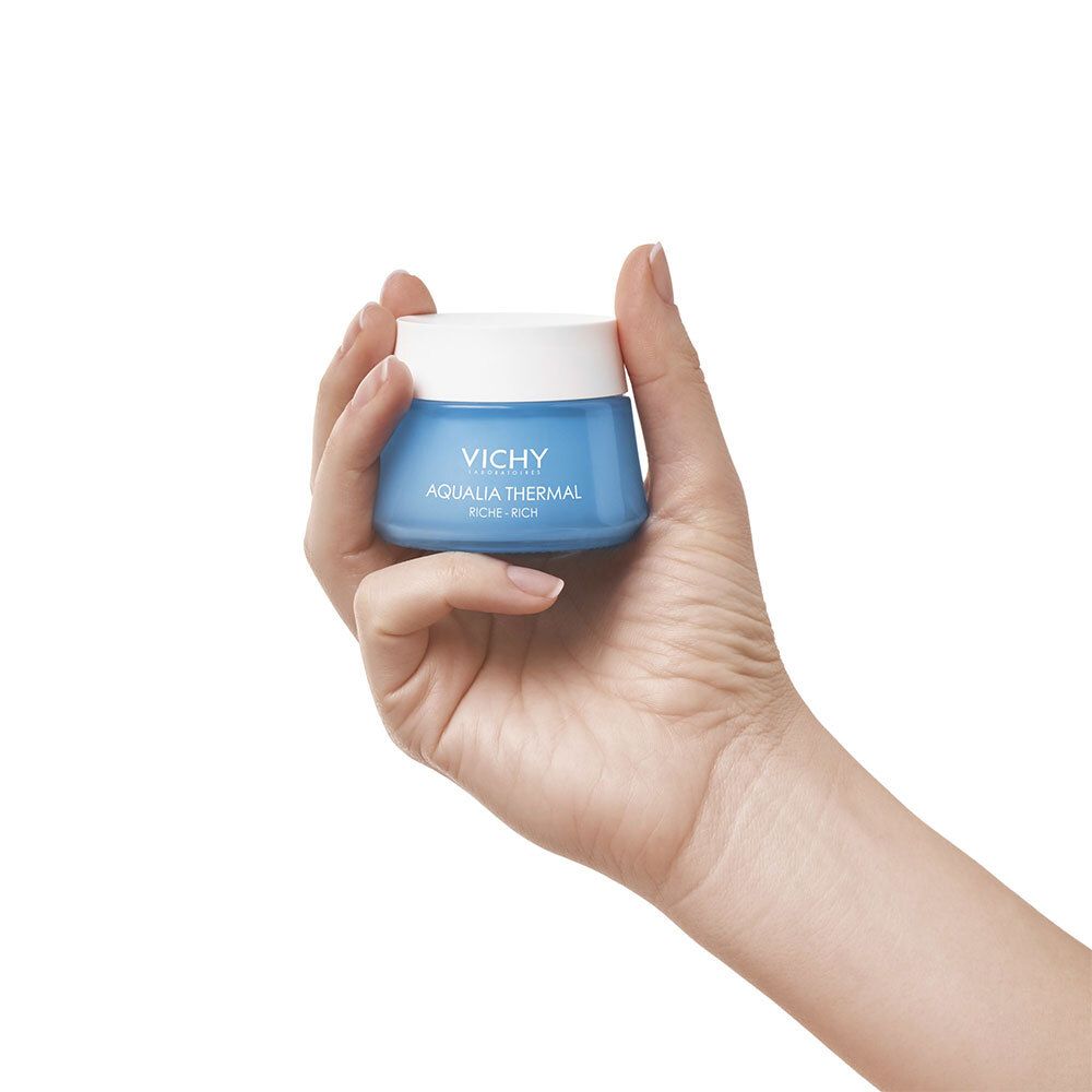Hand hält blaues Cremeglas mit weißem Deckel. Aufschrift: VICHY, AQUALIA THERMAL, RICHE-RICH.