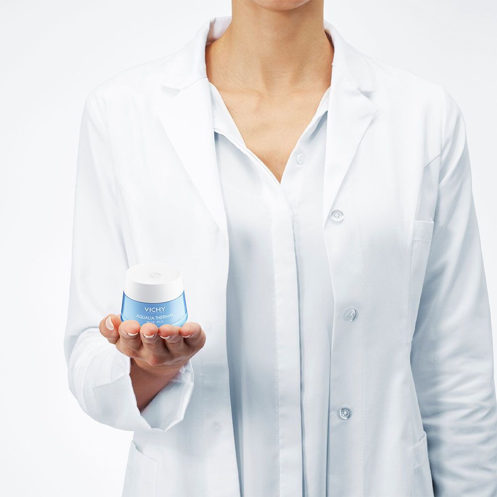 Person in weißem Kittel hält blaues Cremeglas. Aufschrift: VICHY, AQUALIA THERMAL, RICHE-RICH.
