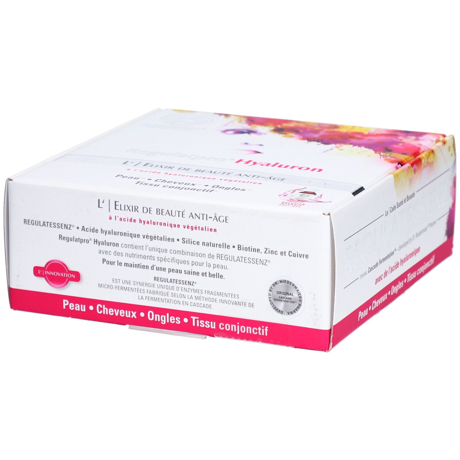 Weißer Karton mit rosa Akzenten. Text: L'Elixir de Beauté Anti-Âge, Regulatessenz Hyaluron. Enthält Biotin, Zink und Kupfer. Siegel.