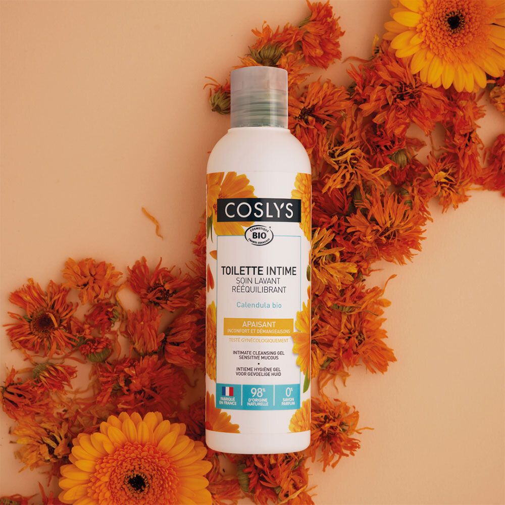 Weiße Flasche mit gelbem Etikett, umgeben von orangefarbenen Blüten. Aufschrift: Coslys, Toilette Intime, Calendula bio.
