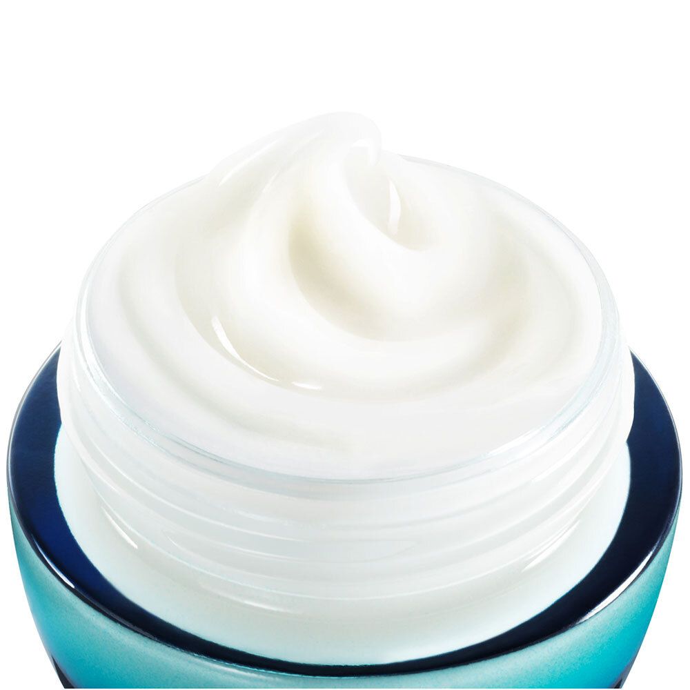 Nahaufnahme der Creme in einem blauen Tiegel. Cremefarbene, gewirbelte Textur.