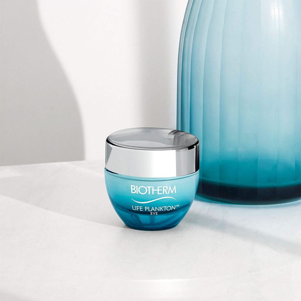 Blau-silberfarbener Tiegel mit BIOTHERM Life Plankton Eye. Neben blauer Vase.