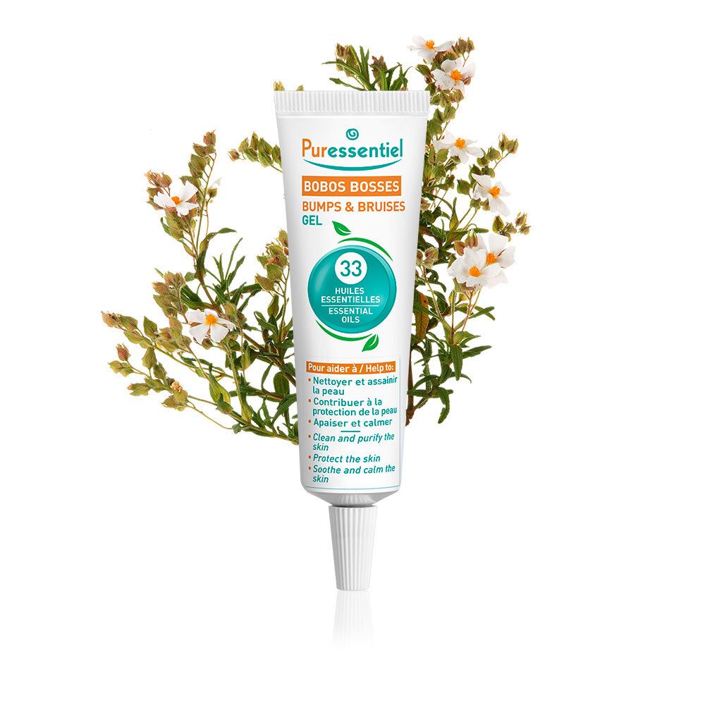 Tube Puressentiel Bobos Bosses Gel. Contient 33 huiles essentielles. Produit devant des fleurs. Inscription: 'Bumps & Bruises'.