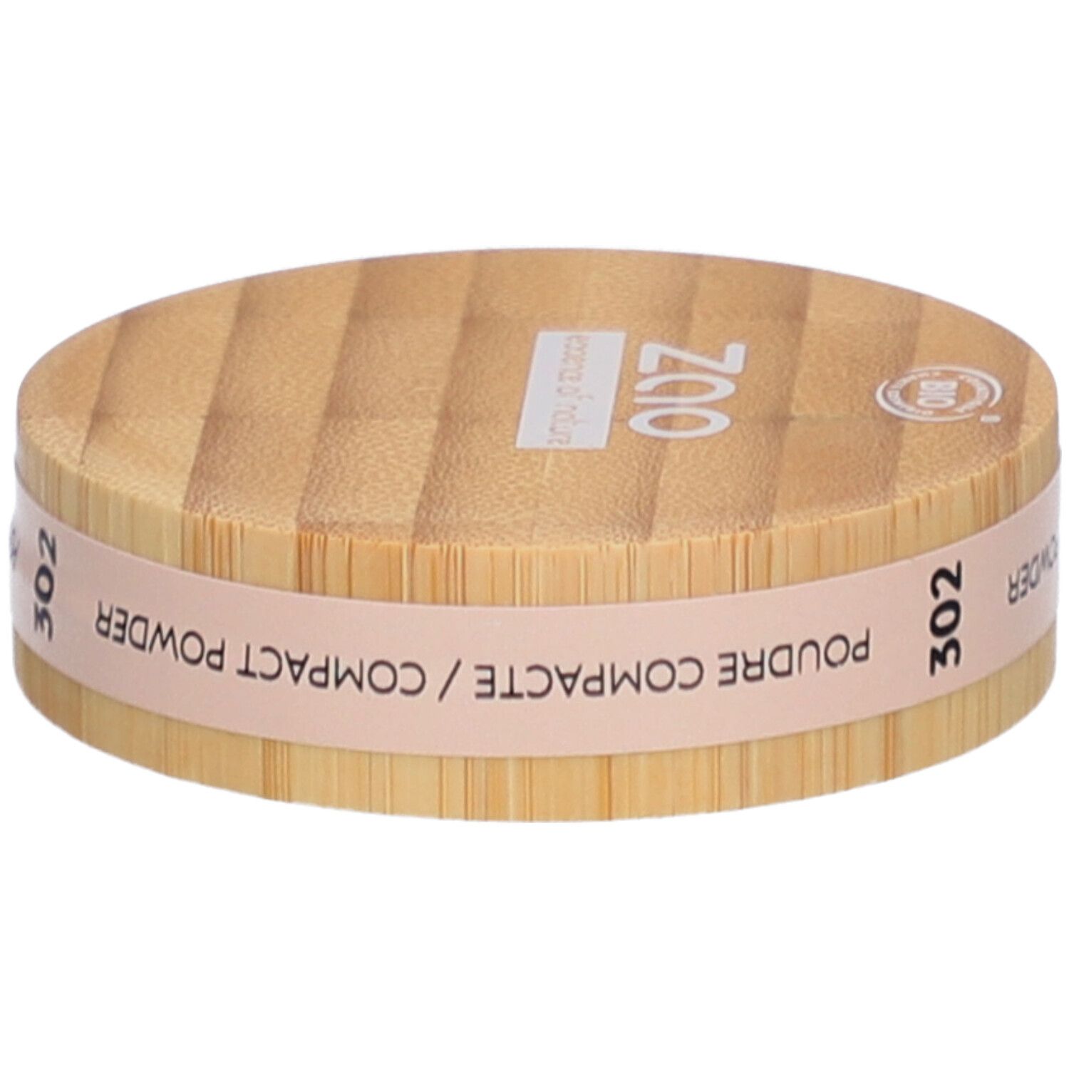 Ronde compactpoederdoos van hout. Opschrift: ZAO, 302, POUDRE COMPACTE. Bio-certificering.