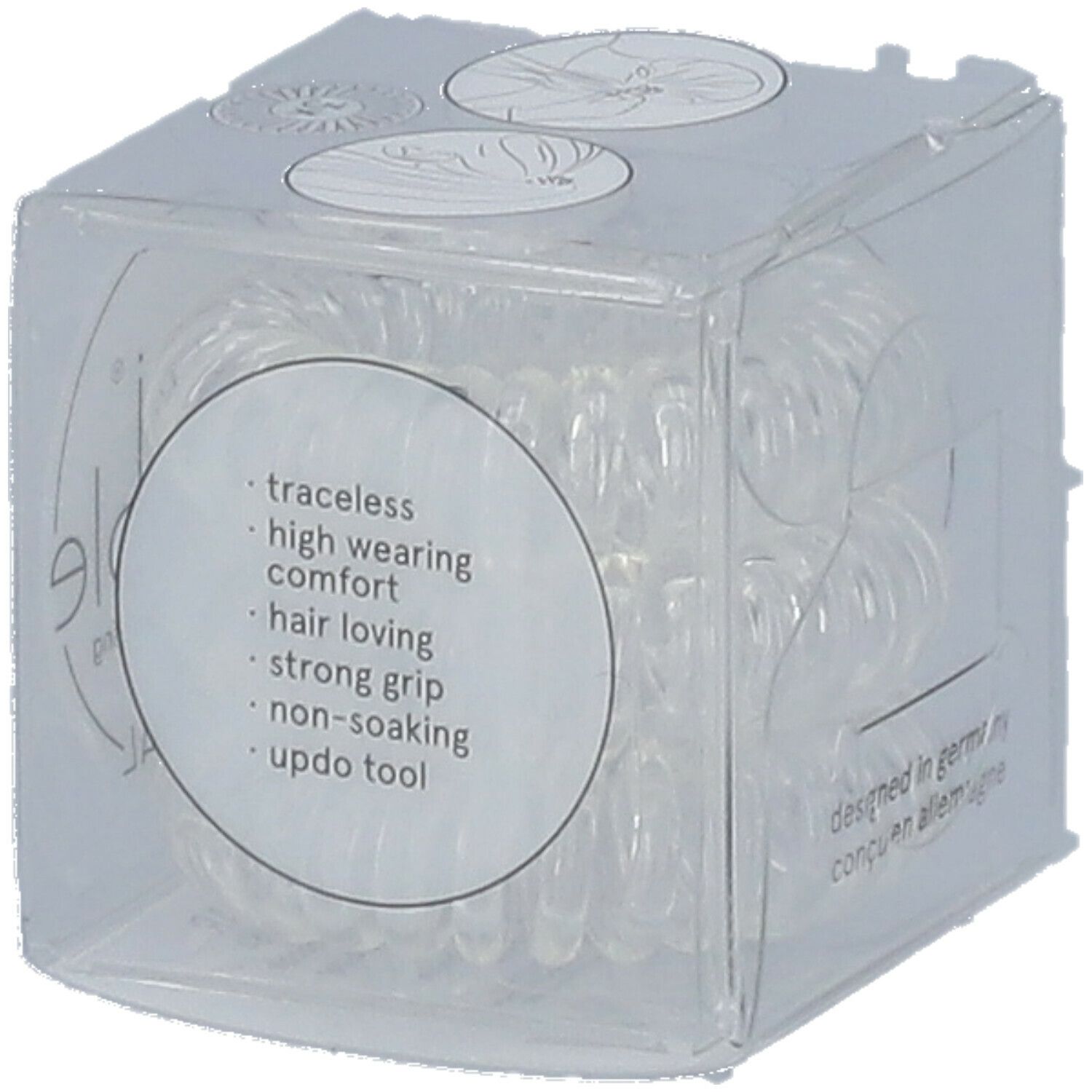 Klare, spiralförmige Haargummis in einer transparenten Würfelverpackung. Auf der Verpackung stehen Produktmerkmale.